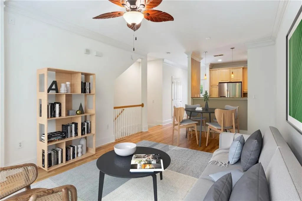 Living room with ornamental molding, ceiling fan, and light wood-type flooring