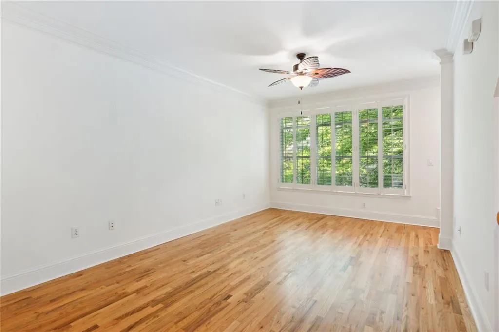 Unfurnished room with crown molding, ceiling fan, and light wood-type flooring