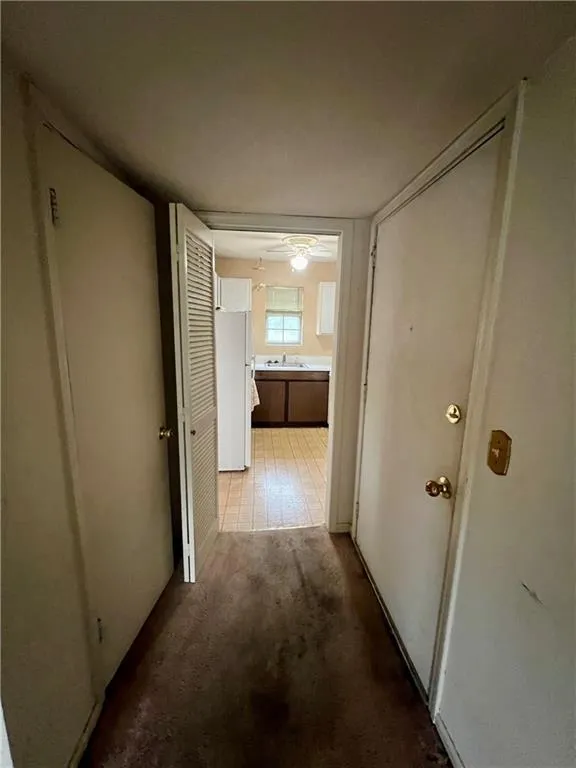 Corridor featuring carpet floors and a sink