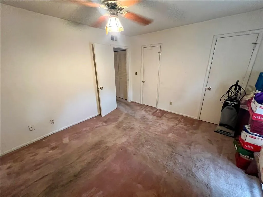 Unfurnished bedroom featuring multiple closets, carpet floors, and ceiling fan