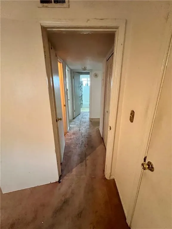 Hallway featuring unfinished concrete flooring