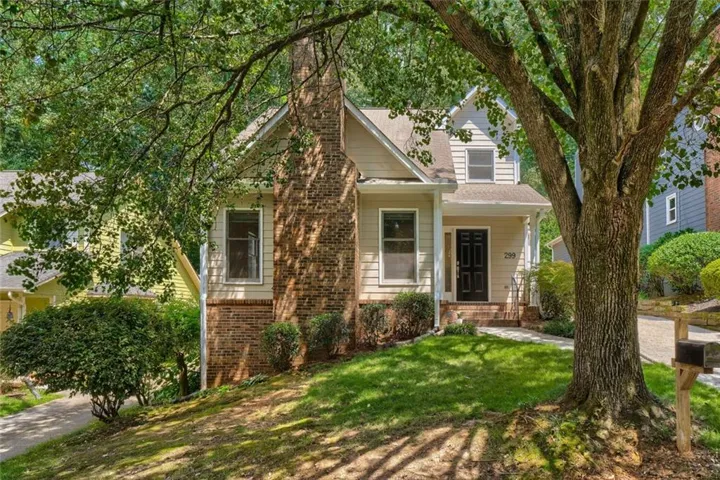 Two-story residence featuring light-colored siding, a prominent brick chimney, and a covered front entry