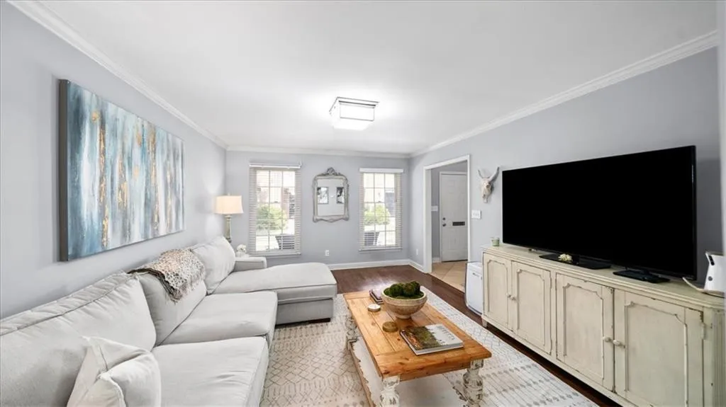 Living room with crown molding and light hardwood / wood-style flooring