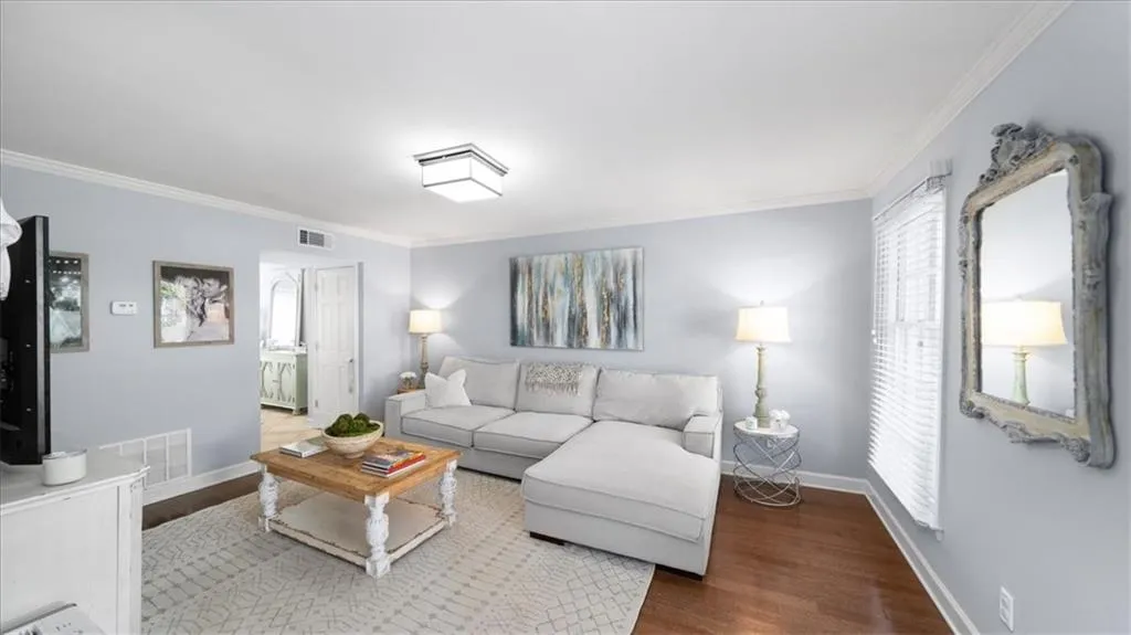 Living room with hardwood / wood-style floors and ornamental molding