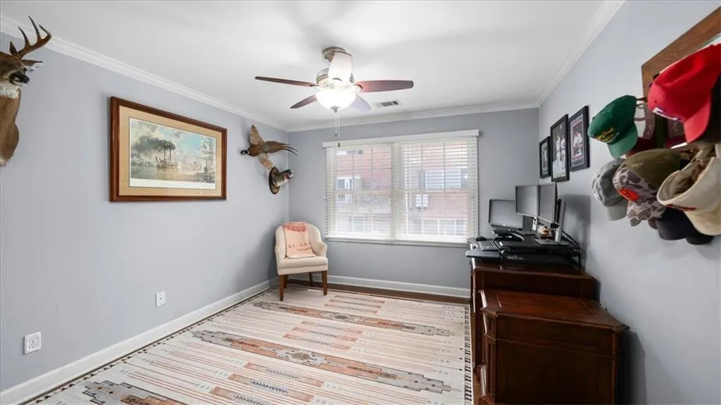Living area with ceiling fan, crown molding, and light hardwood / wood-style floors
