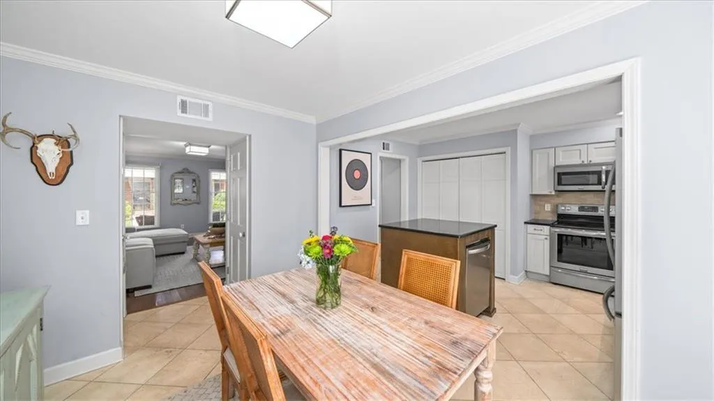 Dining area featuring light tile floors and crown molding