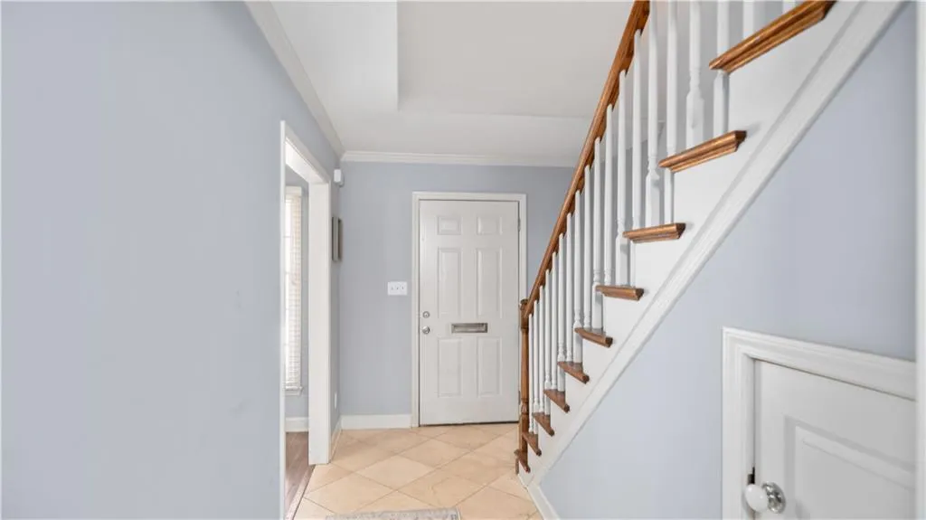Entryway featuring crown molding and light tile flooring