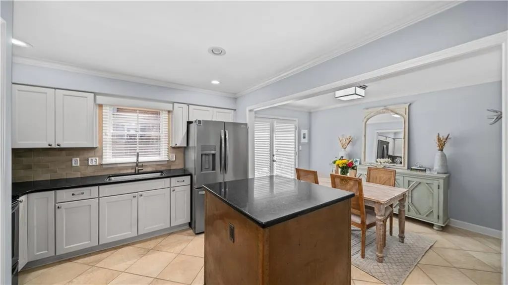 Kitchen with stainless steel appliance tasteful backsplash, light tile floors, and a wealth of natural light