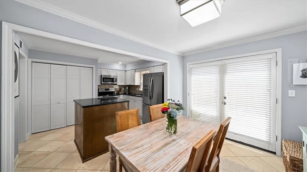 Dining area featuring ornamental molding and light tile floors