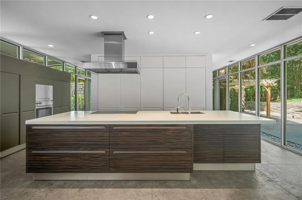 Kitchen with expansive windows, recessed lighting, a large island, island exhaust hood, and dark brown cabinets