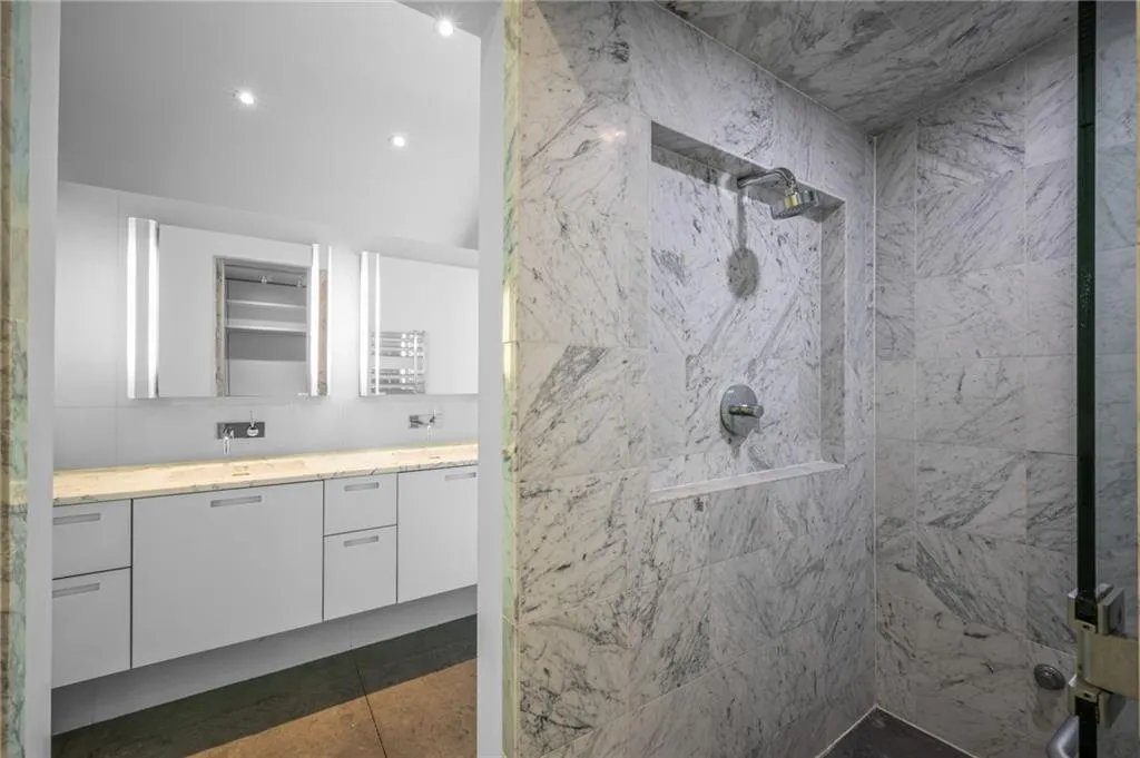 Bathroom featuring vanity, a stall shower, recessed lighting, and tile walls