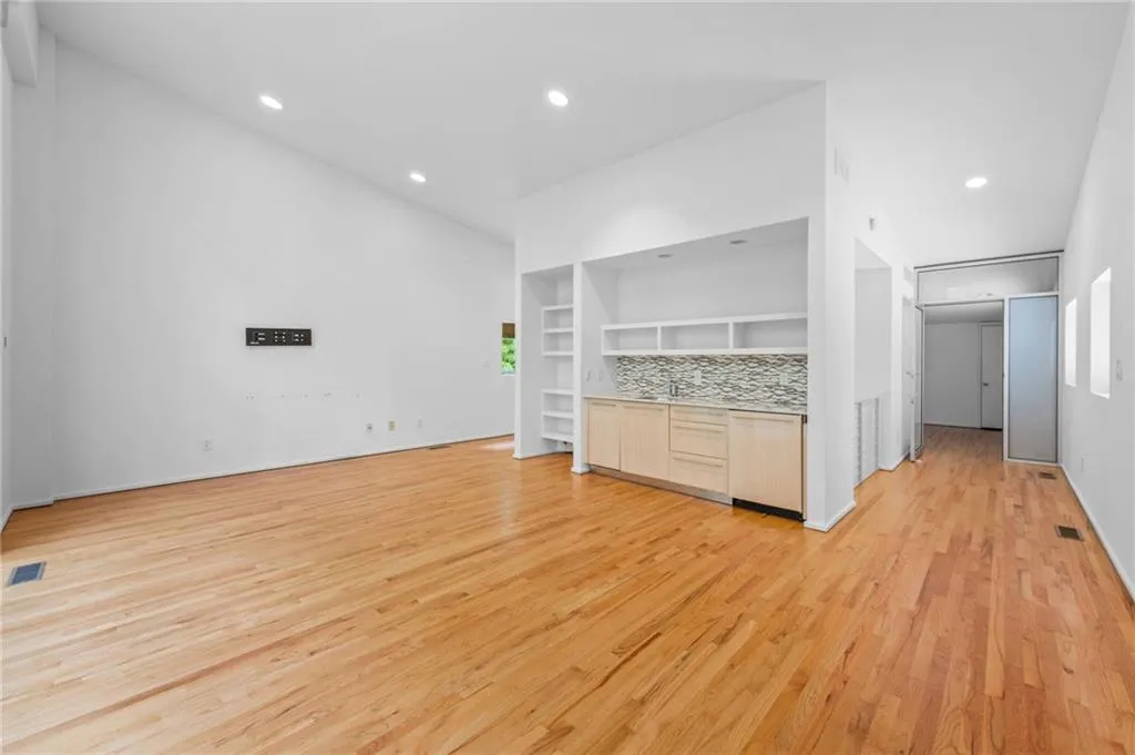 Unfurnished living room featuring light wood-style floors, recessed lighting, and built in features