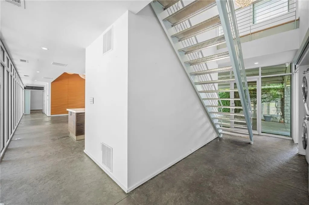 Hall with finished concrete floors, recessed lighting, and washer / dryer