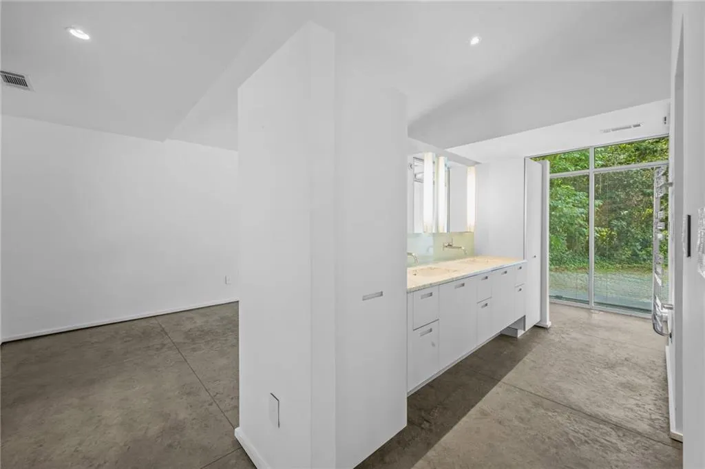 Bathroom featuring vanity, concrete floors, and recessed lighting