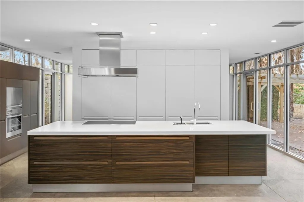 Kitchen with floor to ceiling windows, plenty of natural light, ventilation hood, recessed lighting, and modern cabinets
