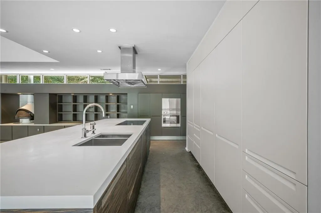 Kitchen featuring recessed lighting, modern cabinets, island exhaust hood, a spacious island, and black electric stovetop