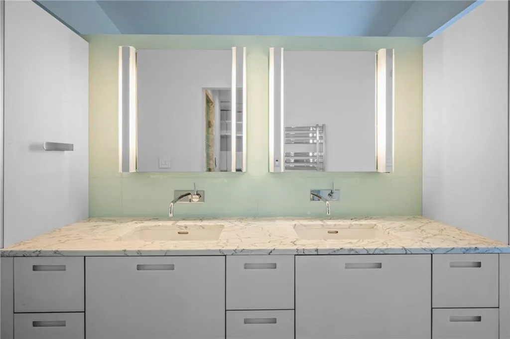 Full bath featuring double vanity and radiator heating unit