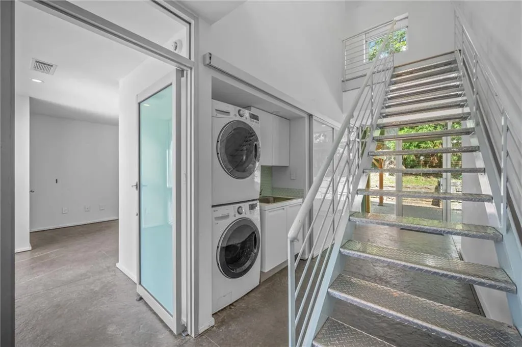 Washroom featuring stacked washing machine and dryer and cabinet space