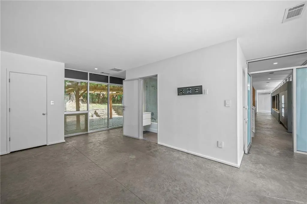 Empty room with finished concrete flooring and baseboards