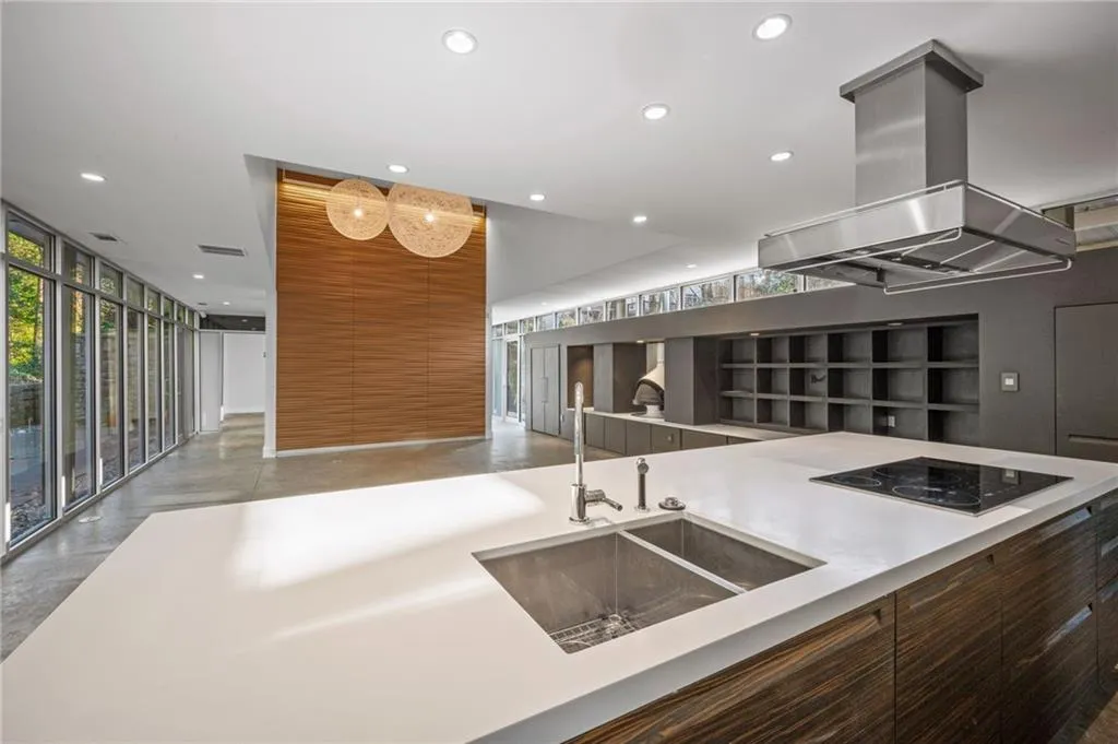 Kitchen with modern cabinets, finished concrete flooring, island range hood, a wall of windows, and open floor plan