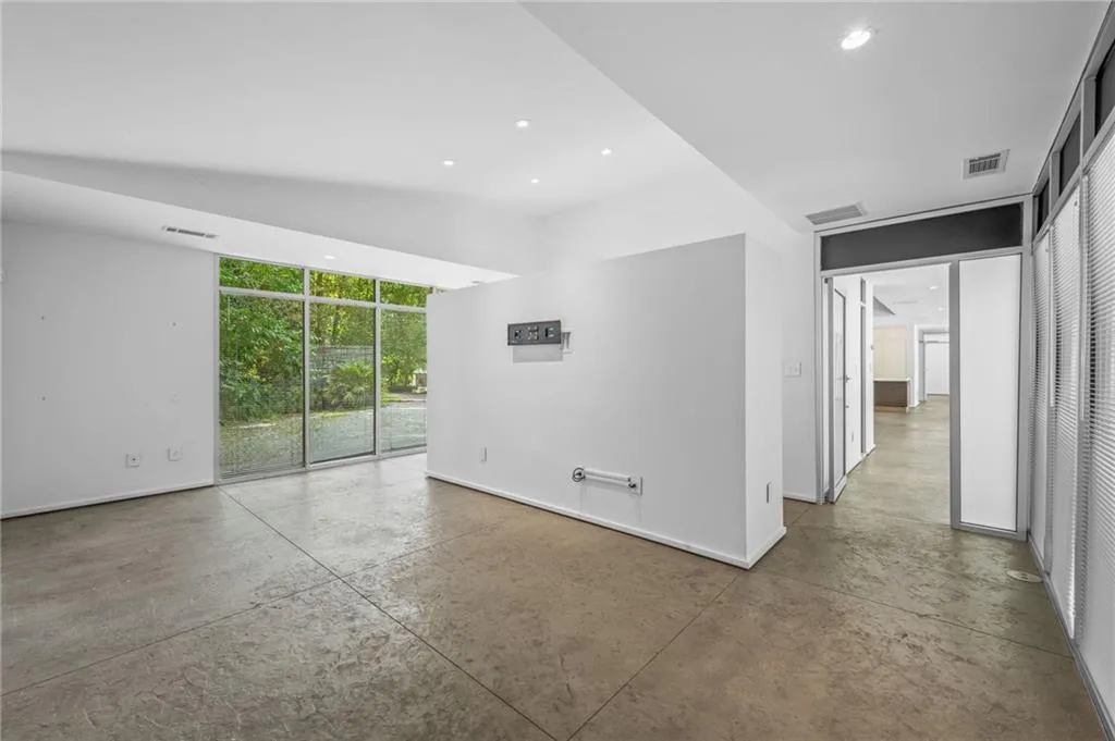 Unfurnished room with recessed lighting, concrete floors, and a wall of windows