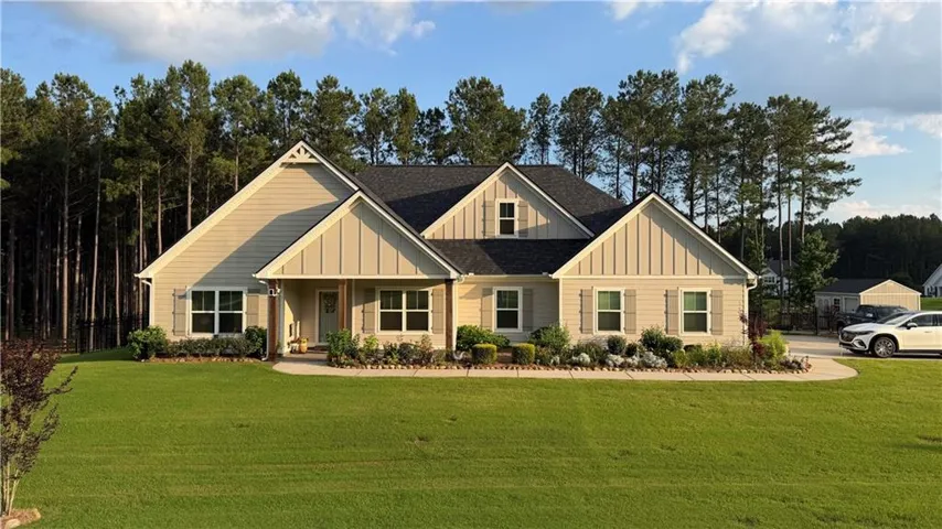 Ranch-style residence featuring a prominent gable roofline, light-toned siding, and decorative window shutters
