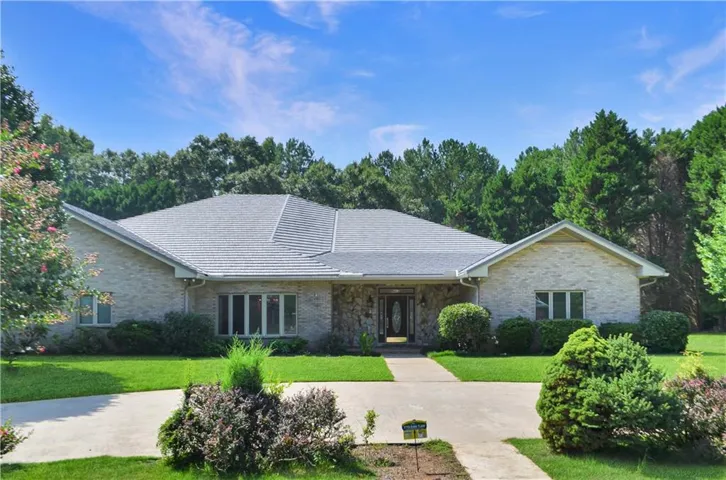 Brick and stone exterior with a gray shingle roof