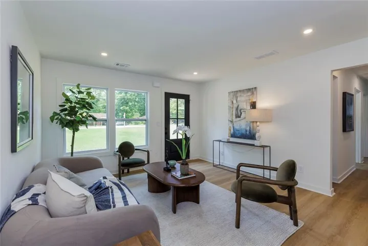 Bright living space featuring recessed lighting, wood-finish flooring, white walls, and multiple windows