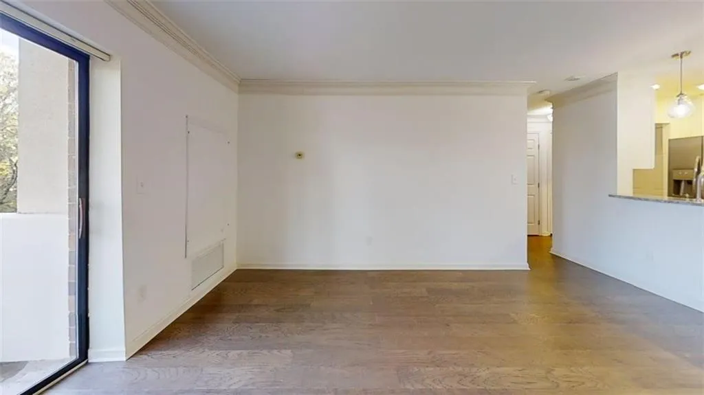 Unfurnished room with wood finished floors and crown molding