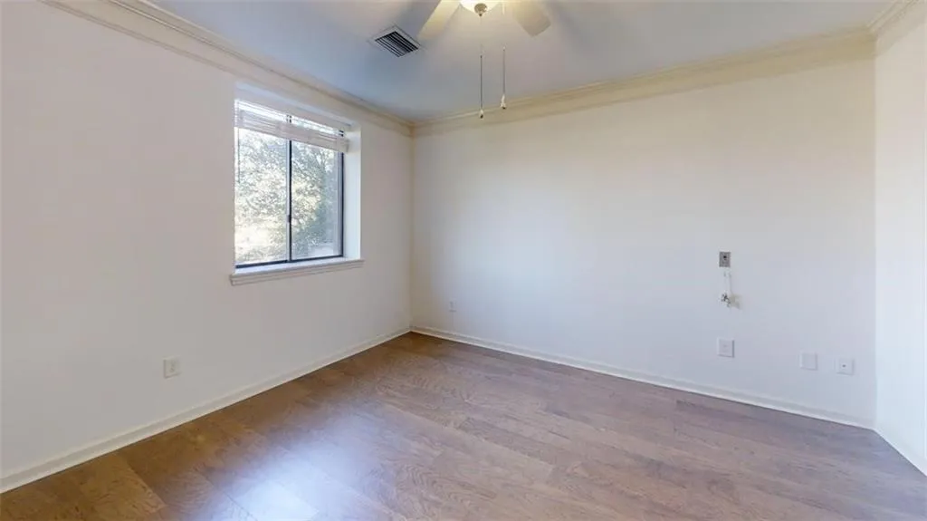 Unfurnished room featuring ornamental molding, wood finished floors, and a ceiling fan