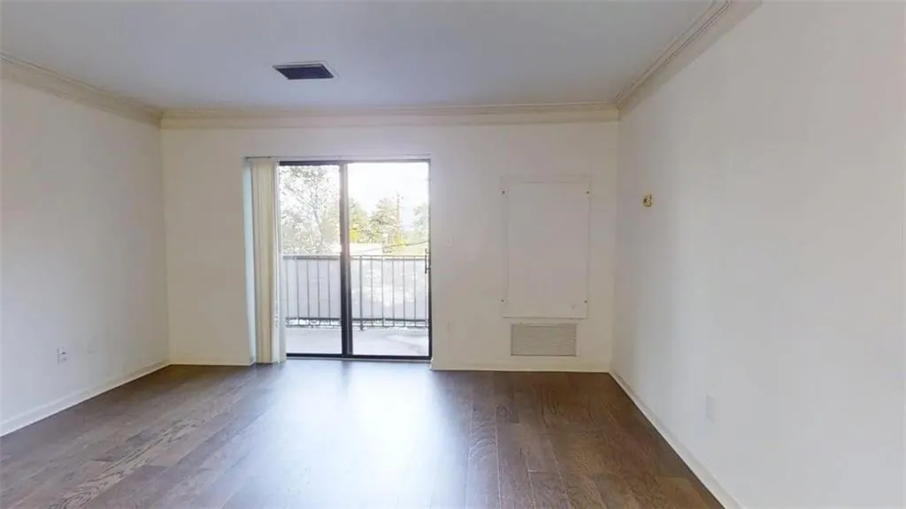 Spare room with dark wood-style flooring and crown molding