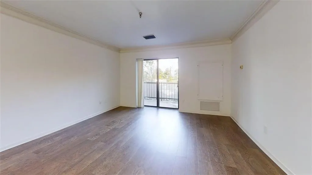 Unfurnished room with wood finished floors and ornamental molding