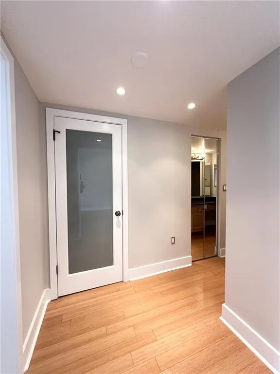 Corridor featuring light wood-style flooring and recessed lighting