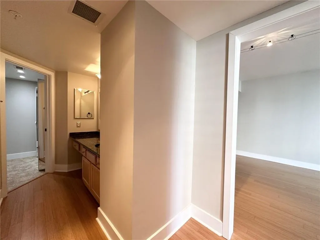 Corridor with light wood-style flooring and baseboards