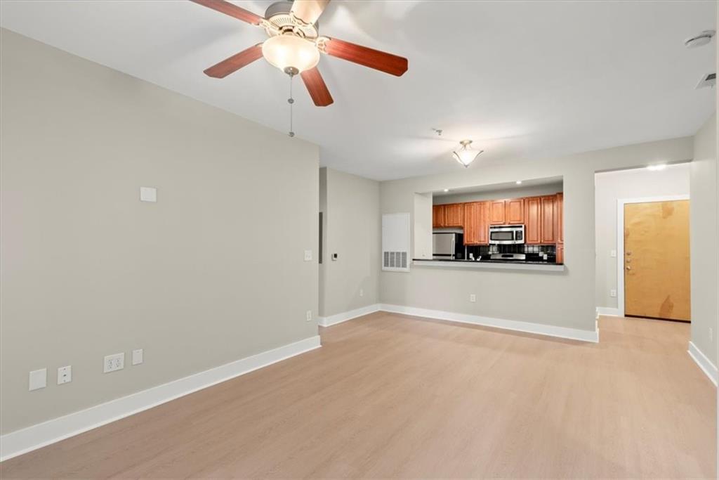 Unfurnished living room with light wood-type flooring and ceiling fan