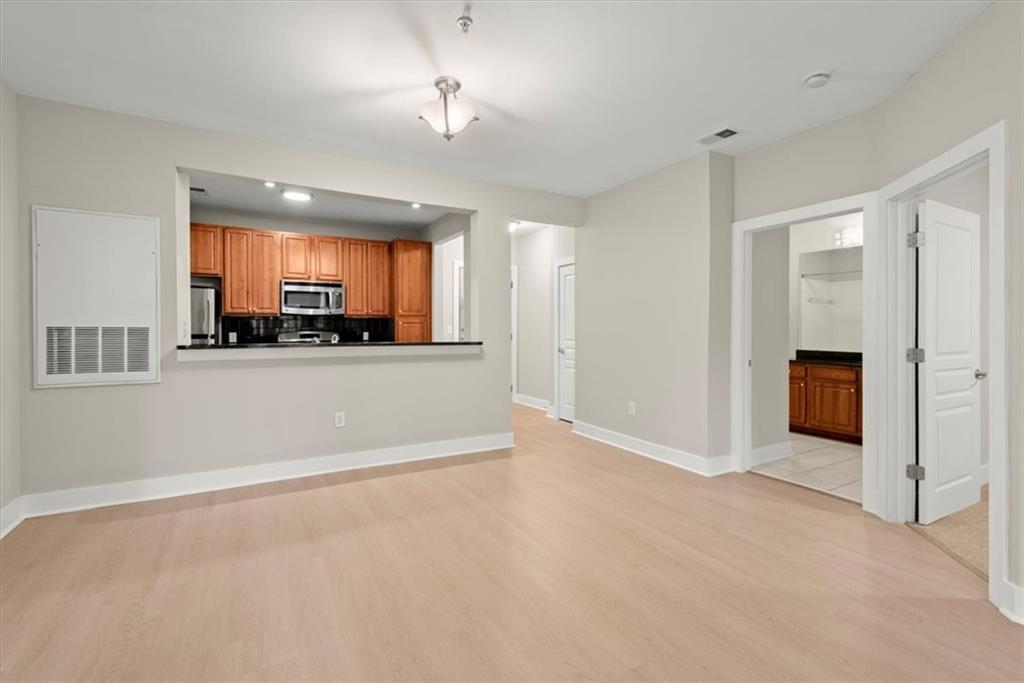 Kitchen with light hardwood / wood-style flooring, fridge, kitchen peninsula, and backsplash