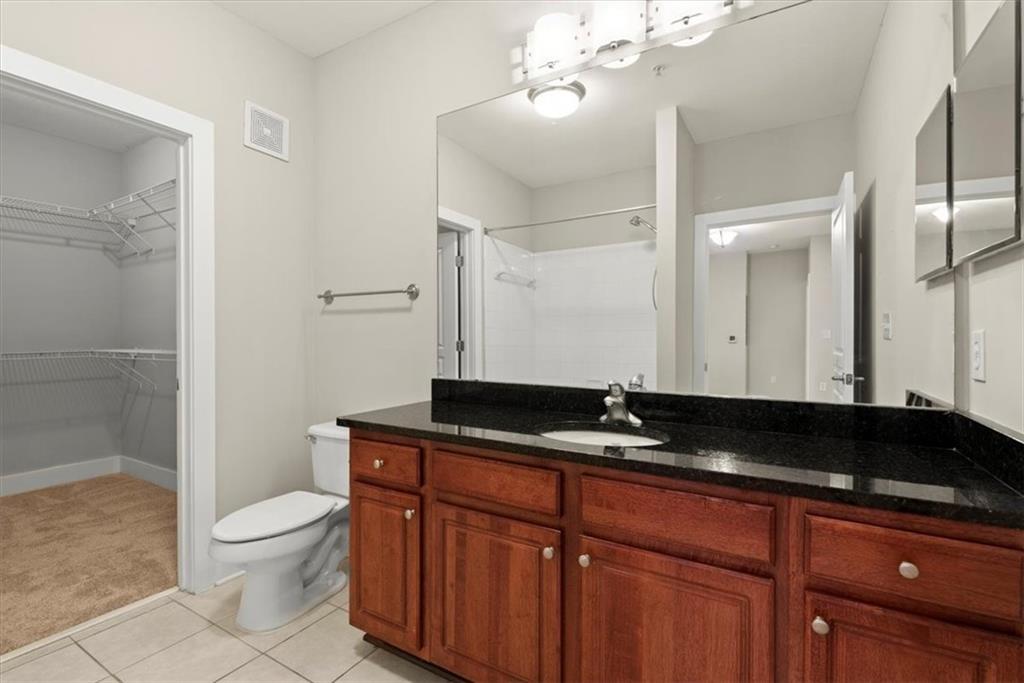 Bathroom featuring vanity, toilet, and tile flooring