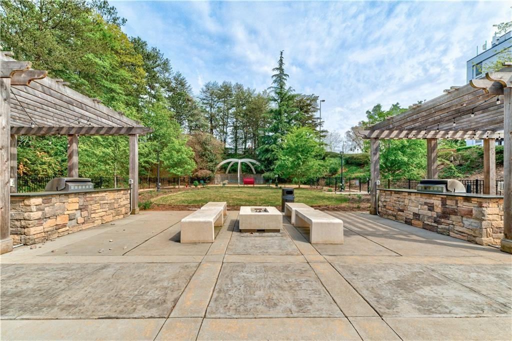 View of patio featuring a pergola, a playground, and an outdoor kitchen
