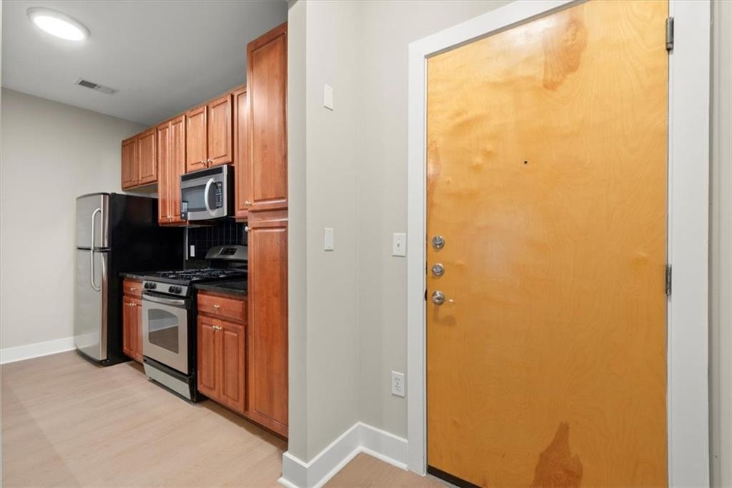 Kitchen with stainless steel appliances and light hardwood / wood-style flooring