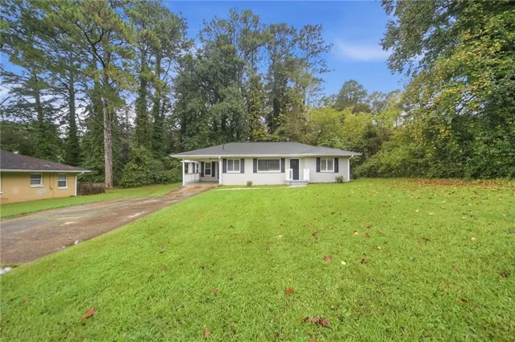 Ranch-style exterior with a light gray facade, black shutters, and a covered porch entry