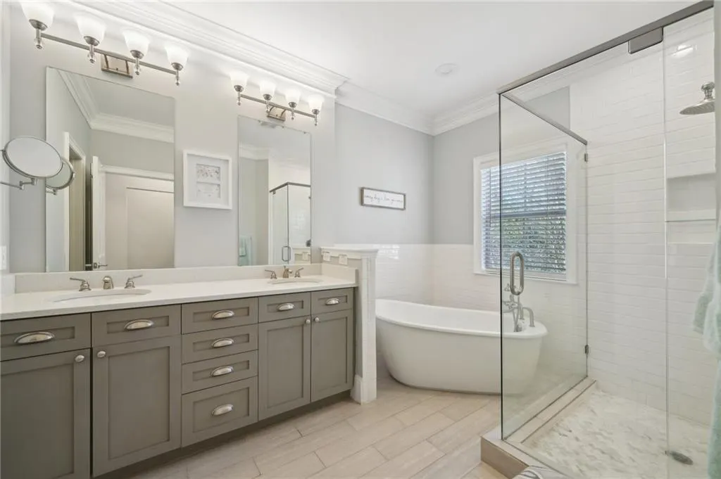 Full bathroom featuring a freestanding tub, a sink, a stall shower, and crown molding