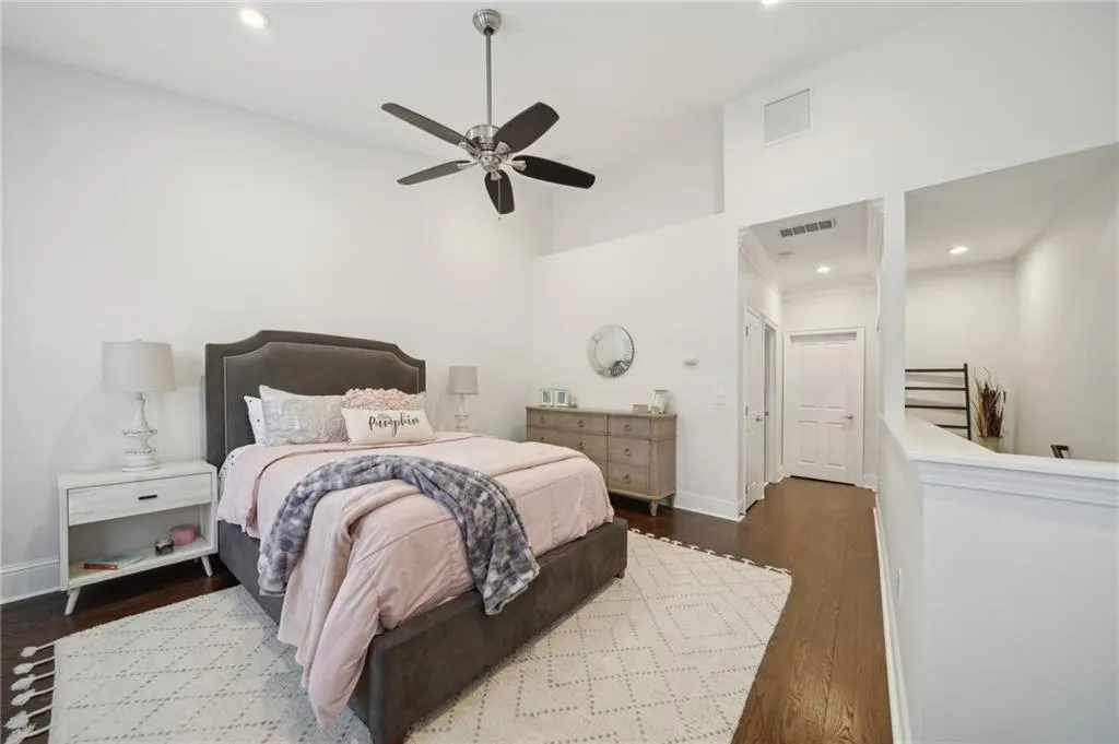 Bedroom featuring baseboards, visible vents, wood finished floors, and ceiling fan