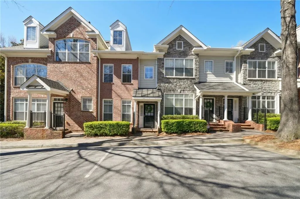 Townhome / multi-family property featuring stone siding and brick siding