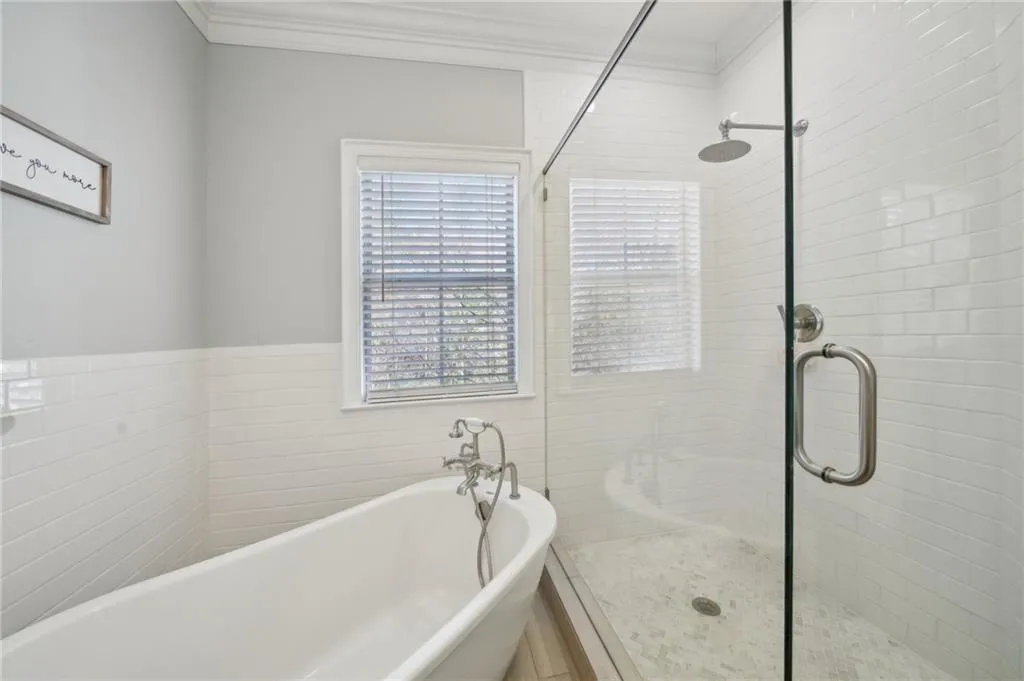 Full bathroom with crown molding, a shower stall, and a freestanding bath