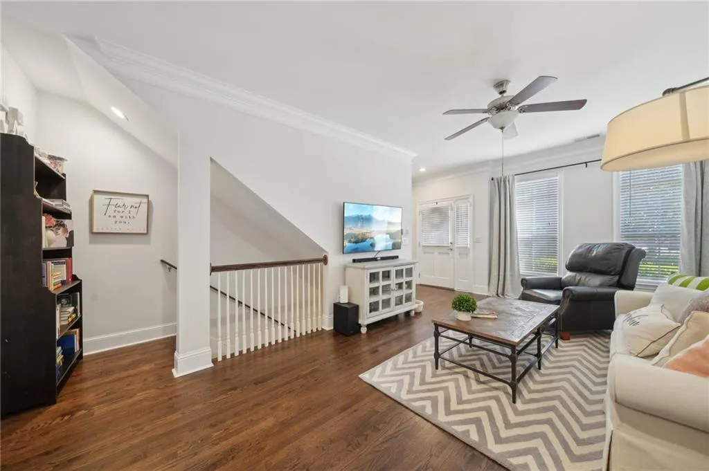 Living room featuring a ceiling fan, wood finished floors, baseboards, ornamental molding, and recessed lighting