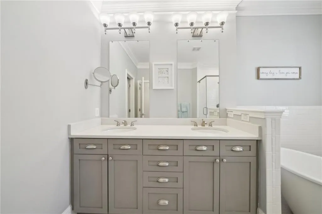 Bathroom with crown molding, a sink, a soaking tub, and a shower stall