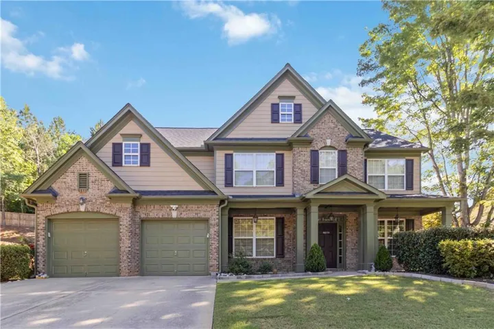 Two-story residence featuring a brick and siding exterior with a two-car garage
