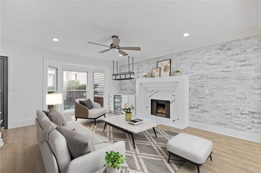 Living area featuring ornamental molding, a high end fireplace, light wood-style flooring, recessed lighting, and ceiling fan