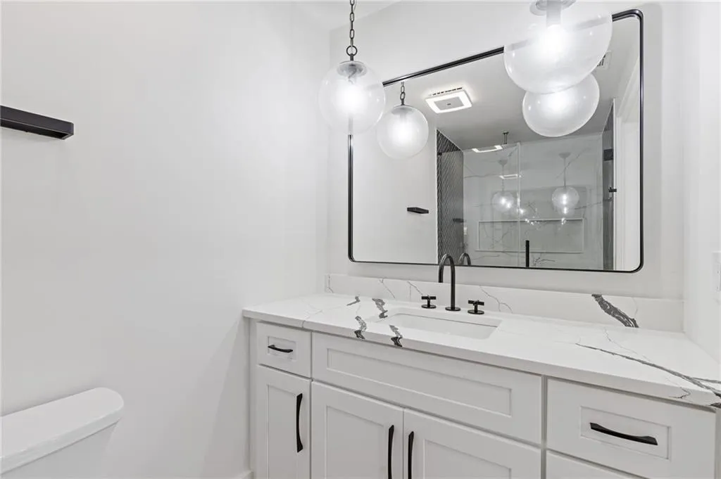 Bathroom featuring vanity and a marble finish shower