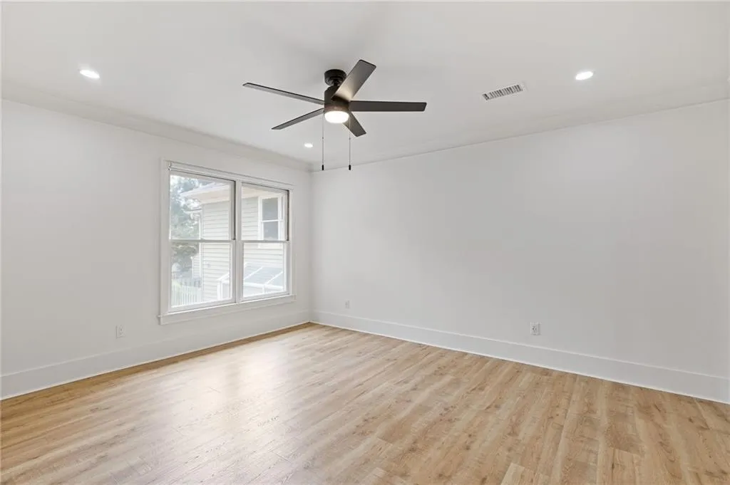 Spare room featuring light wood-style floors, crown molding, recessed lighting, and a ceiling fan